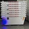 Stack of large white industrial crates with red 'DO NOT FILL ABOVE RIM' labels, stored against a concrete wall and metal shutter; blue/purple lighting at base.